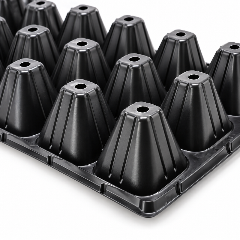 Close-up of black seedling tray cell bottoms showing drainage holes.