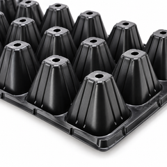 Close-up of black seedling tray cell bottoms showing drainage holes.